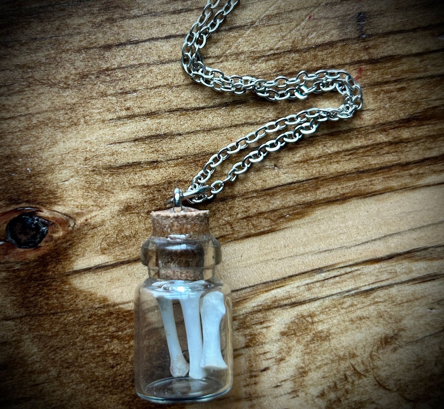 Curio bottle with bones pendant